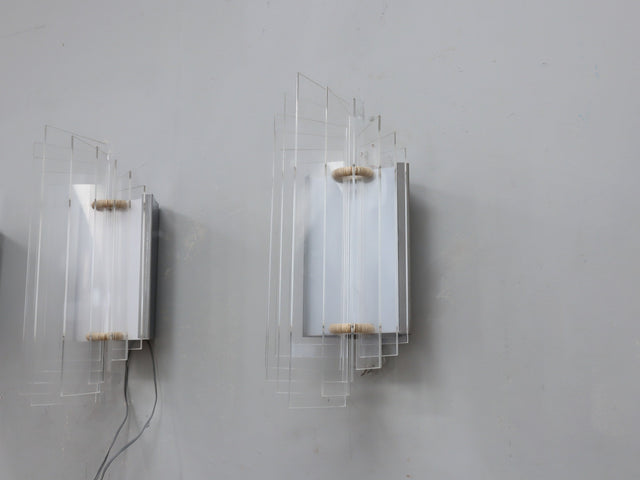 set of three 1970s Italian wall sconces masterfully combines geometric lines and layered transparency, chrome-plated steel frame, central white opaline plexiglass diffuser, enhanced by surrounding lamellar acrylic blades
