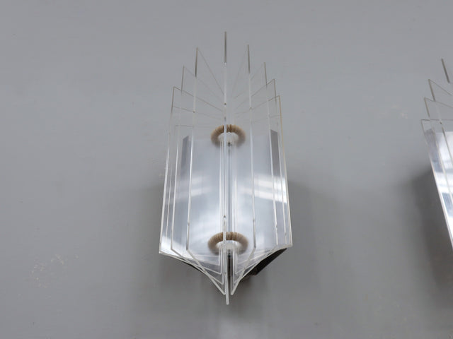 set of three 1970s Italian wall sconces masterfully combines geometric lines and layered transparency, chrome-plated steel frame, central white opaline plexiglass diffuser, enhanced by surrounding lamellar acrylic blades