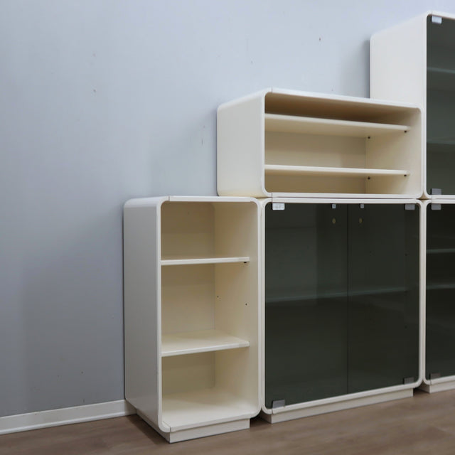 1960s Italian Space Age white lacquered modular bookcase system with smoked glass doors and open shelving modules in a clean minimalist set.