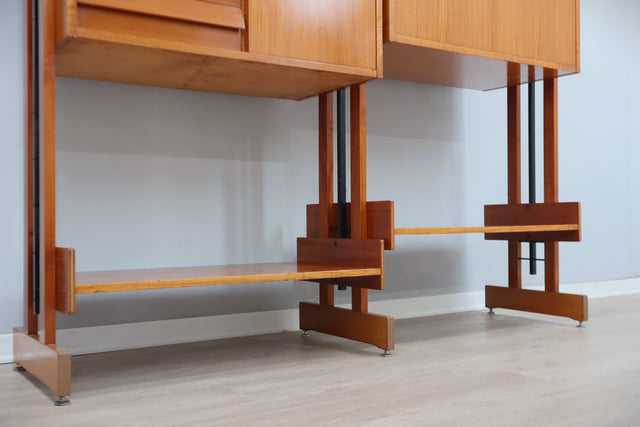 1960s teak modular bookcase a perfect balance between functionality and modernist design. The vertical wooden and metal structure supports shelves and storage modules that can be flexibly arranged