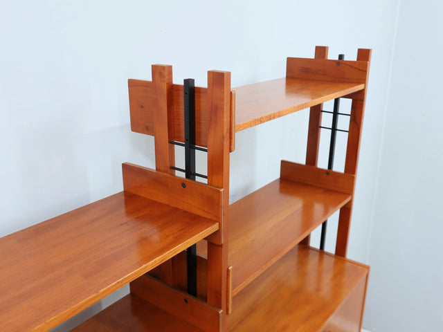 1960s teak modular bookcase a perfect balance between functionality and modernist design. The vertical wooden and metal structure supports shelves and storage modules that can be flexibly arranged
