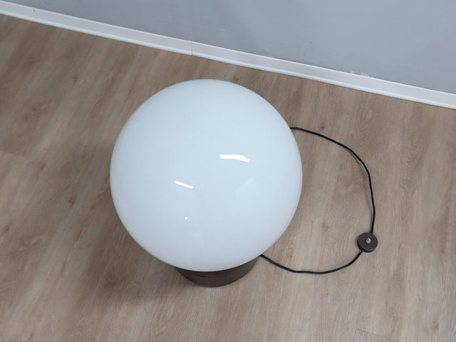 Gae Aulenti "Mezzo Oracolo" lamp for Artemide. Its commanding opaline glass globe acts as a luminous dome, diffusing light with a warm, ethereal glow. Below, the cylindrical metal base