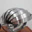 Pair of 1970s Henri Mathieu French kinetic spiral table lamps in brushed steel and chrome illuminated on a wooden sideboard.