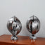 Pair of 1970s Henri Mathieu French kinetic spiral table lamps in brushed steel and chrome illuminated on a wooden sideboard