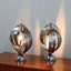 Pair of 1970s Henri Mathieu French kinetic spiral table lamps in brushed steel and chrome illuminated on a wooden sideboard