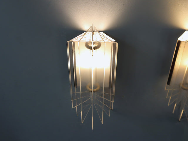 set of three 1970s Italian wall sconces masterfully combines geometric lines and layered transparency, chrome-plated steel frame, central white opaline plexiglass diffuser, enhanced by surrounding lamellar acrylic blades