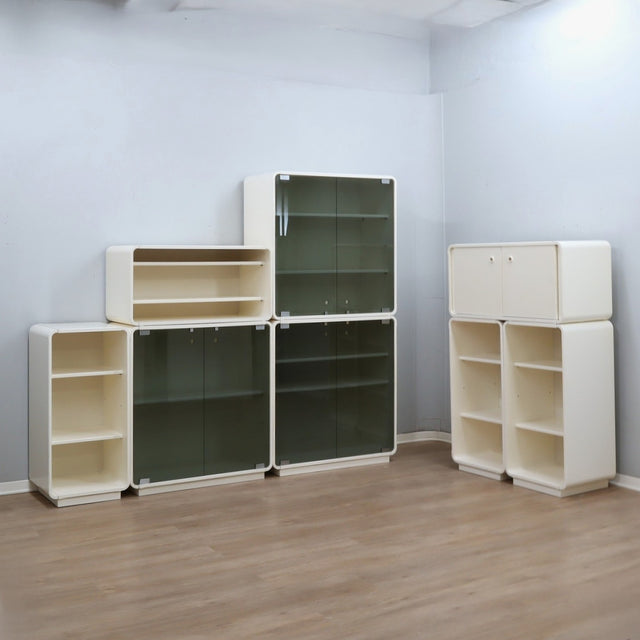 1960s Italian Space Age white lacquered modular bookcase system with smoked glass doors and open shelving modules in a clean minimalist set.   